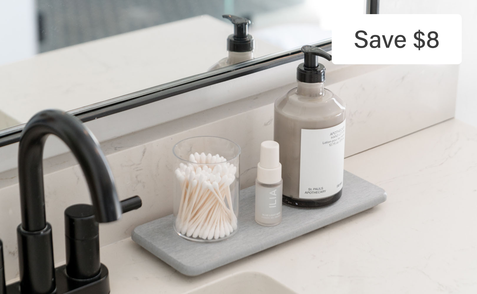 Bathroom counter with soap, lotion, and cotton swabs.